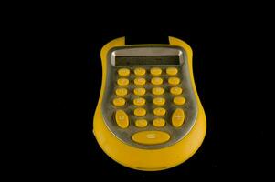 a yellow calculator on a black background photo