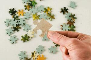 a hand holding a piece of puzzle photo