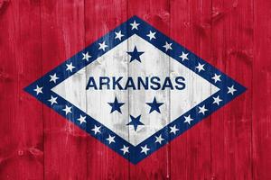 bandera de Arkansas estado Estados Unidos bandera en un texturizado antecedentes. concepto collage. foto
