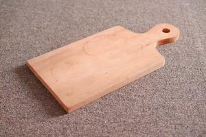 Wooden cutting board on the table. Kitchen utensils. photo