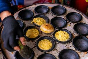 Vietnamese Street Food in Da Lat city, Vietnam - Banh can on the warm ember stove kitchen. Food and travel concept. photo