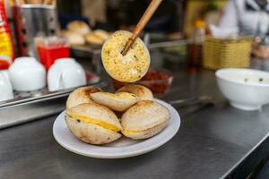 Vietnamese Street Food in Da Lat city, Vietnam - Banh can on the warm ember stove kitchen. Food and travel concept. photo