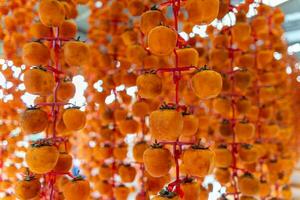 Hanged vietnamese persimmons, traditional food - Dried persimmons in Dalat, Vietnam photo
