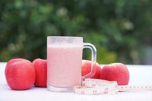 Pink fruits smoothie  in glass, outdoor background. Concept, healthy beverage for health. Well being and weight loss menu. Homemade refreshing fruit drinks. High fibers, detox. photo