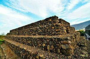 a stone wall in the middle of a field photo