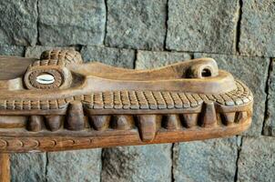 a carved wooden crocodile head on a table photo