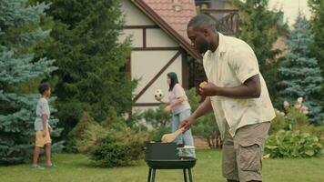 een Afrikaanse vader kookt rooster groenten voor zijn multi-etnisch familie. video