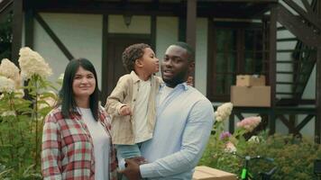 Portrait of a multi-ethnic family with keys who bought a new house. African dad, Caucasian mom, son. video