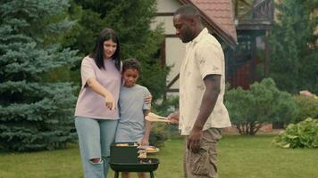 un africain papa cuisiniers gril des légumes pour le sien Multi-éthnique famille. video