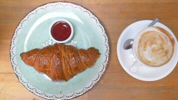 kaffe och croissant på träbord, ovanifrån. video