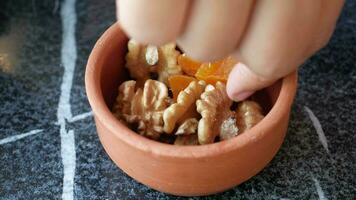 walnut and dried peach fruit on in a small bowl on tiles background video