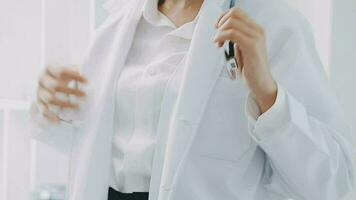 Close-up of a hand of a female doctor using a stethoscope to checking lung for a middle-aged patient who has a fever and comes to see the doctor at the health care center. video