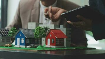 fastighetsmäklare presenterar och rådgör med kund till beslutsfattande teckna försäkringsformulär avtal, hemmodell, gällande bolåneerbjudande för och villaförsäkring. video