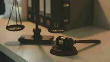 Business and lawyers discussing contract papers with brass scale on desk in office. Law, legal services, advice, justice and law concept picture with film grain effect video