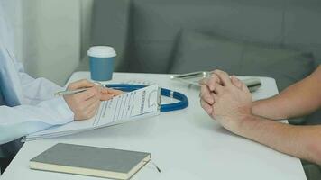 Doctor and patient sitting and talking at medical examination  video