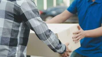 Delivery man giving a cardboard box to a man  video