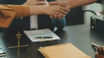 zaken en advocaten bespreken contractpapieren met koperen schaal op bureau in kantoor. wet, juridische diensten, advies, rechtvaardigheid en wet concept foto met film grain effect video