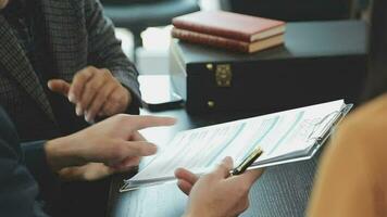 zaken en advocaten bespreken contractpapieren met koperen schaal op bureau in kantoor. wet, juridische diensten, advies, rechtvaardigheid en wet concept foto met film grain effect video