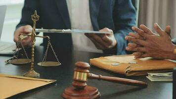 Business and lawyers discussing contract papers with brass scale on desk in office. Law, legal services, advice, justice and law concept picture with film grain effect video