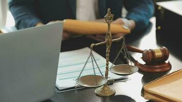 Business and lawyers discussing contract papers with brass scale on desk in office. Law, legal services, advice, justice and law concept picture with film grain effect video