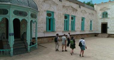 A group of tourists walk through the courtyard of Sitorai MohiHosa Palace video