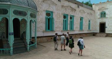 A group of tourists walk through the courtyard of Sitorai MohiHosa Palace video