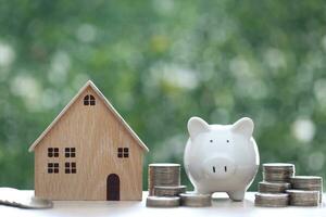 Finance, Model house with piggy bank on natural green background,Business investment and real estate concept photo