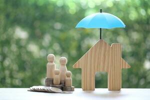 Protection,Model family with model house and stack of coins money on natural green background, Finance insurance and Safe investment concept photo