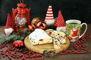 Sliced Chrismas stollen with powdered sugar and christmas decoration photo