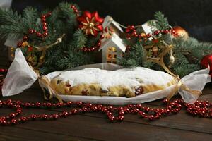 Sliced Chrismas stollen with powdered sugar and christmas decoration photo