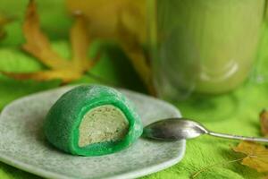 vistoso japonés dulces daifuku o mochi rebanado. dulces cerca arriba en el plato con taza de matcha té foto