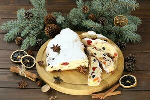 Sliced Chrismas stollen with powdered sugar and christmas decoration photo