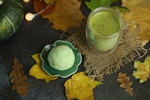 vistoso japonés dulces daifuku o mochi rebanado. dulces cerca arriba en el plato con taza de matcha té foto