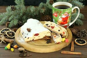 Sliced Chrismas stollen with powdered sugar and christmas decoration photo