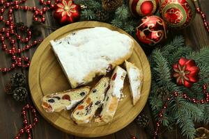 Sliced Chrismas stollen with powdered sugar and christmas decoration photo