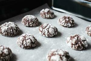 Chocolate cookies with powdered sugar on baking tray. Close-up. photo