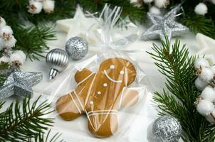 Navidad composición con pan de jengibre hombre y abeto ramas en un blanco de madera antecedentes. de cerca. selectivo enfocar. foto