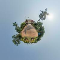 coconut trees in jungle in Indian tropic village on sea shore on little planet in evening sky, transformation of spherical 360 panorama. Spherical abstract view with curvature of space. photo