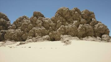 A group of rocks sitting on top of a sandy beach photo