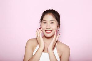 Portrait of beautiful young woman with clean fresh skin on pink background, Face care, Facial treatment. Cosmetology, beauty and spa. Asian women portrait photo