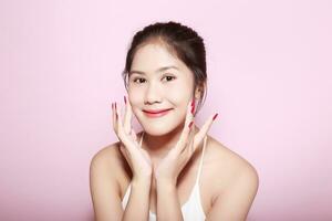 retrato de hermosa joven mujer con limpiar Fresco piel en rosado fondo, cara cuidado, facial tratamiento. cosmetología, belleza y spa. asiático mujer retrato foto