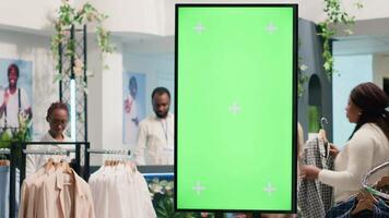 Second hand clothing shop green screen kiosk ready to be used by clients to choose between clothes. Chroma key digital display in thrift shop showcasing available garments sizes video