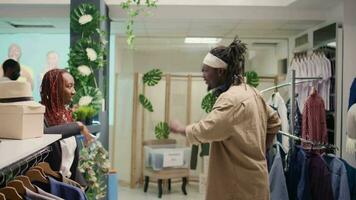 African american couple having fun in thrift shop, doing dance moves. Boyfriend and girlfriend enjoying themselves to nice SH clothing store music, dancing while shopping video