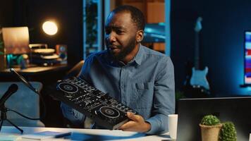 Tech content creator filming technology review of newly released DJ controller, unpacking it and presenting specifications to audience. Influencer showing disc jockey device to subscribers photo