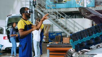 Repairman in car service using advanced virtual reality technology to visualize engine turbine in order to fix it. Knowledgeable garage specialist wearing vr glasses while servicing defective vehicle photo