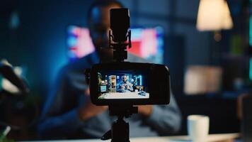 Close up shot on professional recording device in cozy home studio used for filming film video intro for online streaming platforms. Influencer in blurry background greets fanbase, focus on camera photo