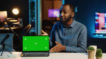 Content creator in studio films newly released green screen gaming laptop video review for tech enthusiasts. Viral online star hosts technology internet show, unboxing mockup notebook device photo