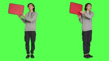 jung Kerl zeigt an Rede Blase im Studio, präsentieren isoliert Copyspace auf Plakatwand Symbol gegen grüner Bildschirm. asiatisch Mann Arbeiten auf Erstellen Marketing Werbung, Werbung. video