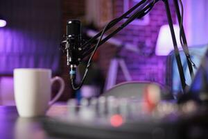 Close up shot of specialised radio equipment used in home personal studio by dj to produce music and record internet show. Empty living room with rgb lights and entertainment gadgets photo