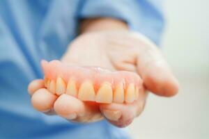 médico participación dientes dentadura en mano para dentista estudiando acerca de odontología. foto